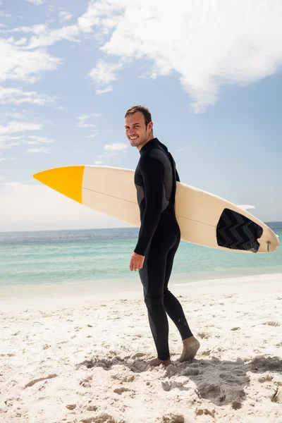 Surfista segurando prancha na praia — Fotografia de Stock