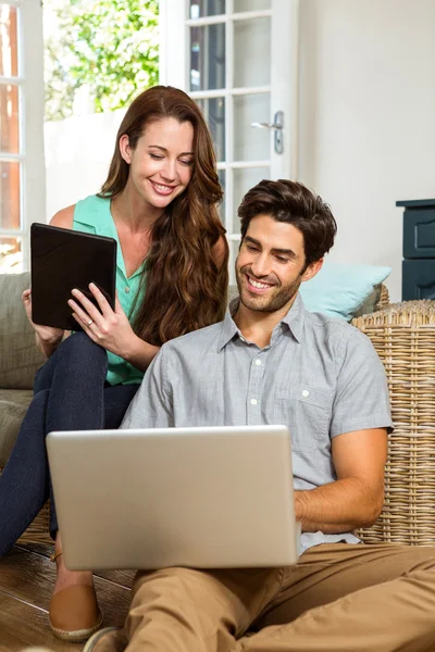 Pareja usando tableta y computadora portátil — Foto de Stock