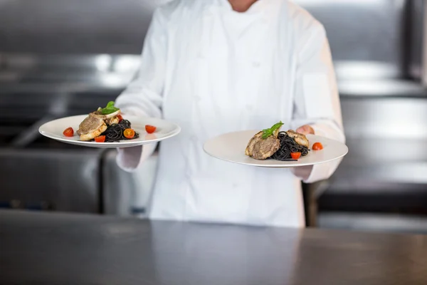 Chef holding plates in kitchen — Stock Photo, Image