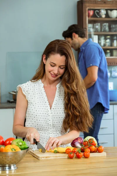 Femme hacher des légumes dans la cuisine — Photo