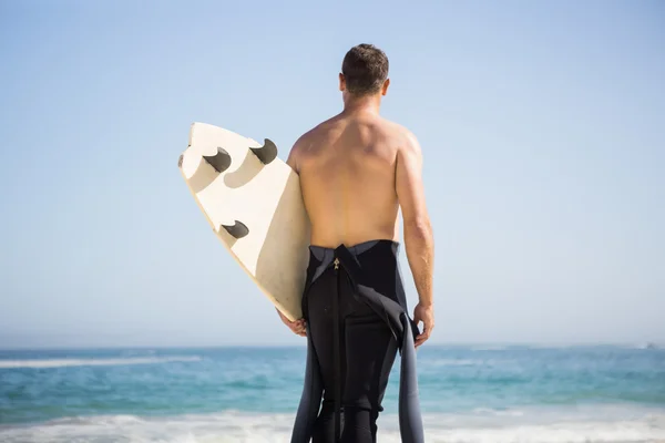 Красивый мужчина держит доску для серфинга — стоковое фото