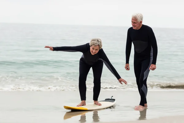 Senior man onderwijs vrouw om te surfen — Stockfoto