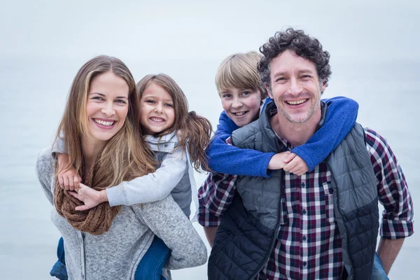 Cheerful parents carrying children — Stock Photo, Image