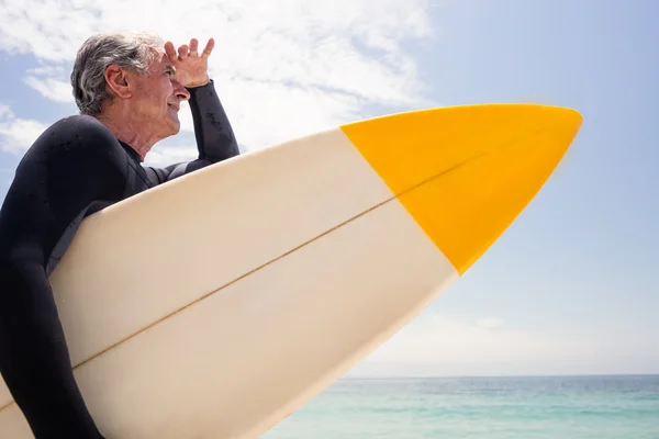 Мужчина с доской для серфинга на пляже — стоковое фото