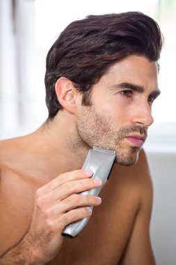 Man shaving with trimmer clipart