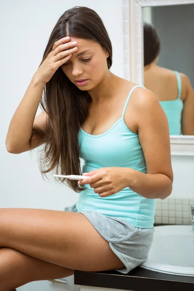 Worried woman looking at pregnancy test — Stock Photo, Image