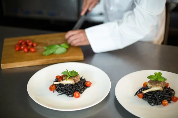 Handsome chef slicing garnish — Stock Photo, Image