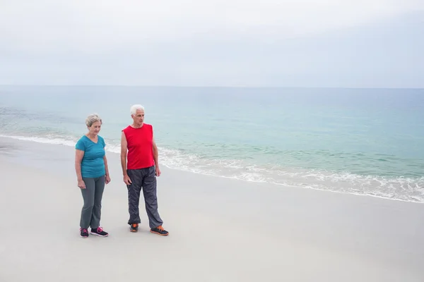 Pareja mayor de pie en la playa — Foto de Stock