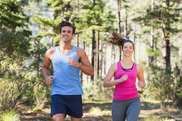 Junges lächelndes Paar joggt — Stockfoto