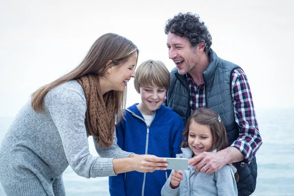 Família alegre com telefone celular — Fotografia de Stock