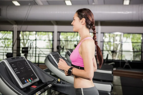 Vrouw met behulp van slimme horloge op loopband — Stockfoto