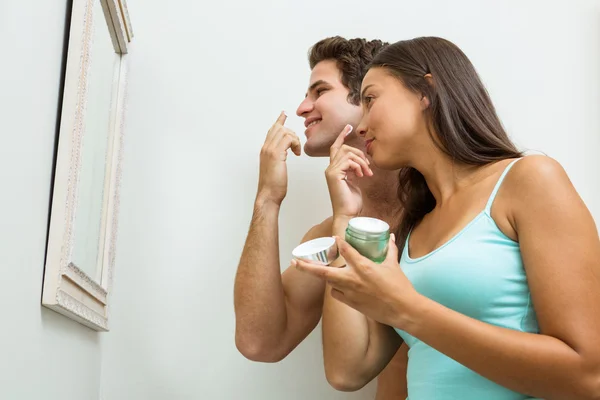 Couple applying moisturizer on face — Stock Photo, Image
