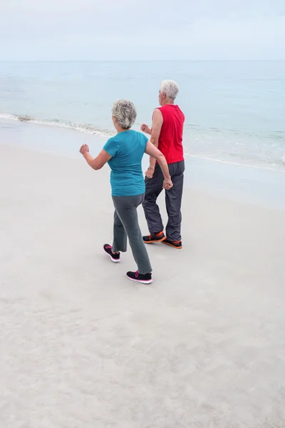 Pareja mayor corriendo en la playa — Foto de Stock