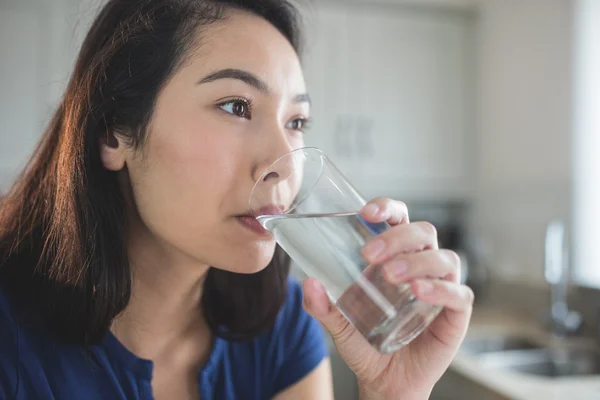 Femme eau potable de cuisine — Photo