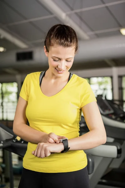 Frau benutzt Smartwatch auf Laufband — Stockfoto