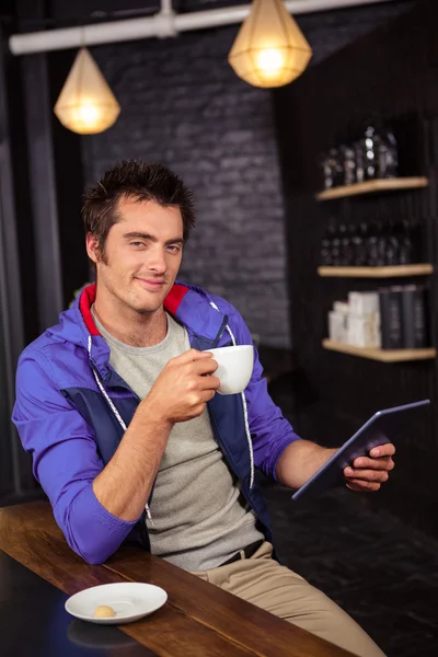 Man using a tablet and drinking coffee — Stock Photo, Image