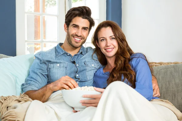 Pareja teniendo palomitas de maíz viendo televisión — Foto de Stock