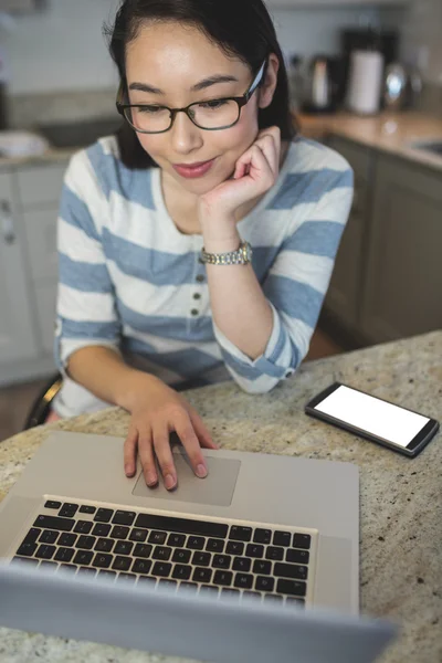 Kvinna med bärbar dator i köket — Stockfoto