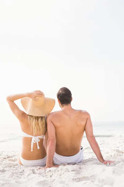 Casal feliz sentado na praia — Fotografia de Stock