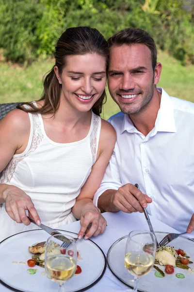 Casal tendo refeição no gramado — Fotografia de Stock