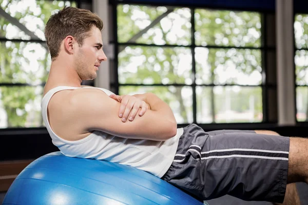 Hombre haciendo ejercicio en la pelota de fitness — Foto de Stock