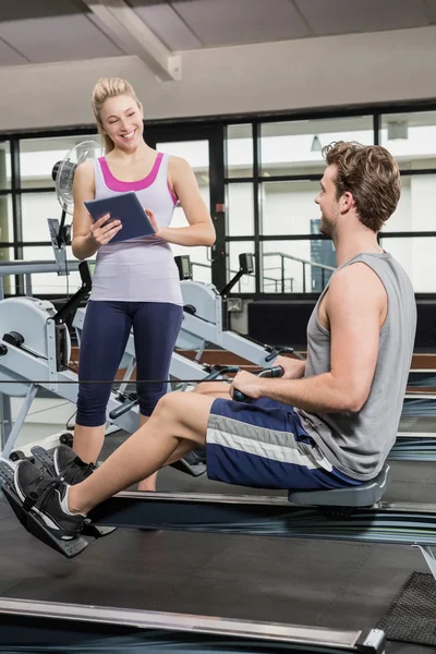 Man exercising on rowing machine — Stock Photo, Image