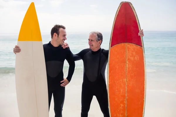 Vader en zoon met surfplanken op strand — Stockfoto