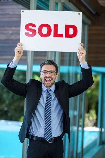 Real estate agent holding sold sign — Stock Photo, Image