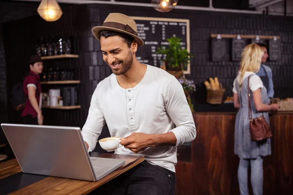 Mann benutzt Laptop und trinkt Kaffee — Stockfoto