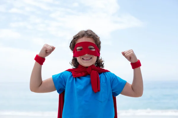 Мальчик в костюме супергероя сгибает мышцы — стоковое фото