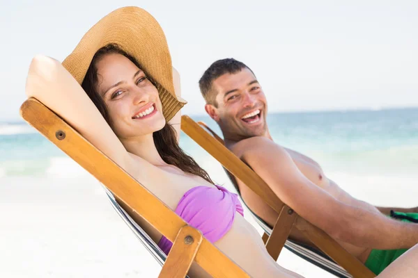 Couple relaxing on deck chairs — Stock Photo, Image