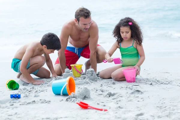 Padre haciendo castillos de arena — Foto de Stock