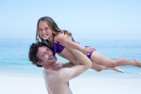 Muž zvedání dcera na břehu moře — Stock fotografie