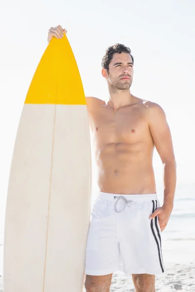 Homem segurando prancha na praia — Fotografia de Stock