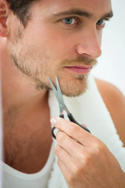 Mann som skjærer skjegg med saks – stockfoto