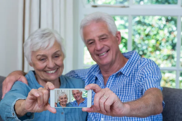 Sonriente pareja jubilada tomando selfie — Foto de Stock