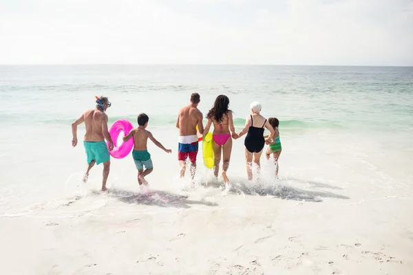 Família correndo em direção ao mar — Fotografia de Stock