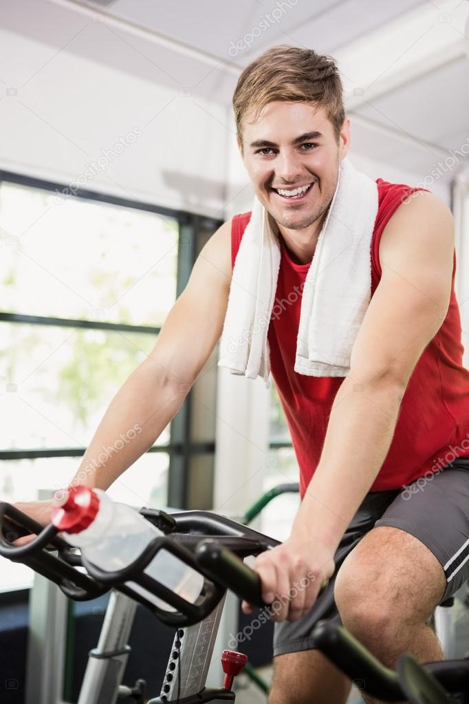 Man working out on exercise bike Stock Photo by Wavebreakmedia