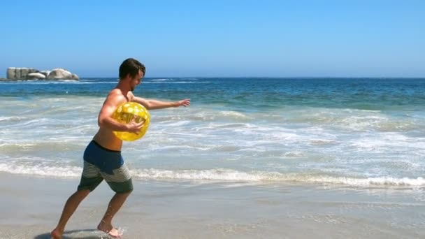 Человек, держащий пляжный мяч — стоковое видео