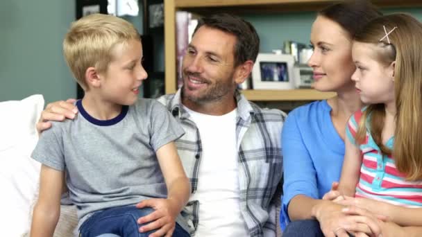 Мила сім'я розмовляє сидячи на дивані — стокове відео
