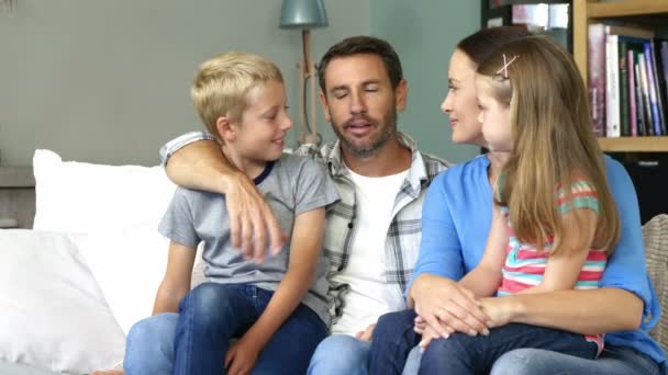 Linda familia hablando sentado en el sofá — Vídeos de Stock