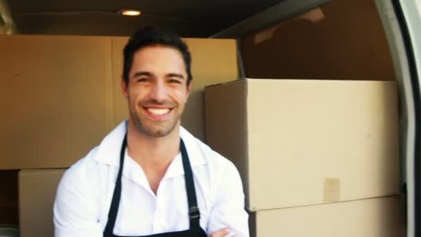 Lächelnder Zusteller sitzt in seinem Lieferwagen — Stockvideo