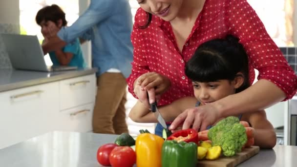 Mère enseignant à sa fille la coupe de légumes — Video