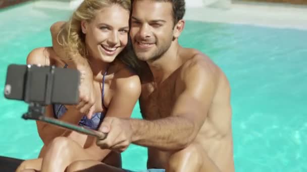 Aantrekkelijke paar nemen selfie bij het zwembad — Stockvideo