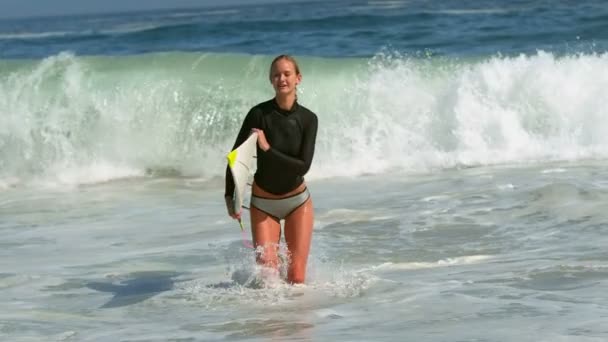 Woman running out of water with surfboard — Stock Video