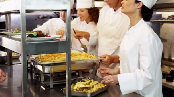 Grupo de chefs dando platos en línea de pedido — Vídeos de Stock