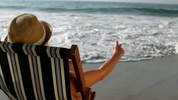 Mulher sentado em uma cadeira de sol — Vídeo de Stock