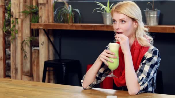 Женщина пьет зеленый молочный коктейль — стоковое видео