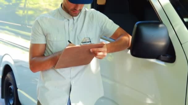 Delivery man writing on clipboard — Stock Video