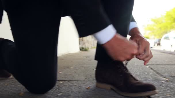 Businessman tying up his shoelaces — Stock Video